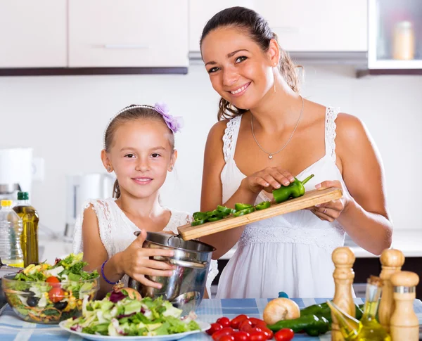 Daughter helping mother to prepare vegetables — Stock Photo, Image