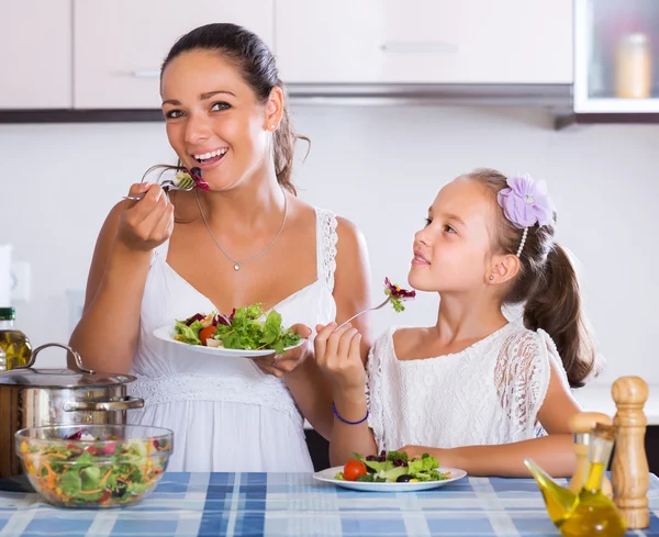 Moeder en dochter eten plantaardige salade — Stockfoto