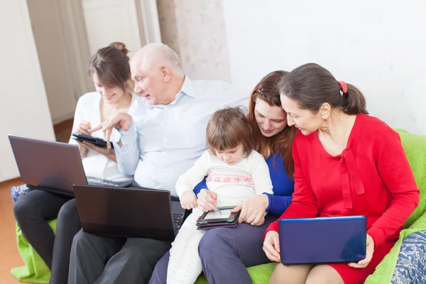 Familie maakt gebruik van verschillende draagbare computers — Stockfoto