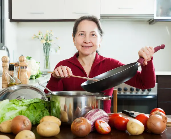 Mogen hemmafru matlagning med pan — Stockfoto