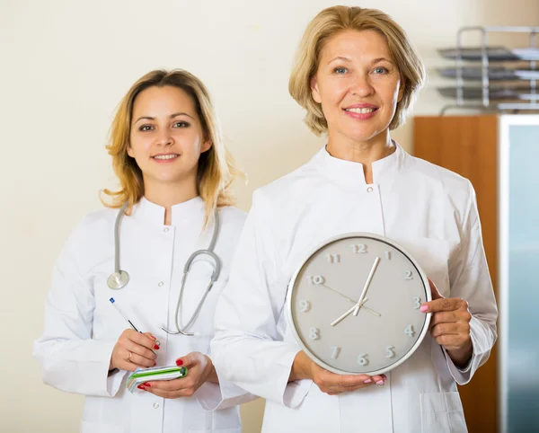 Olgun ve genç doktorlar ile masa saati — Stok fotoğraf