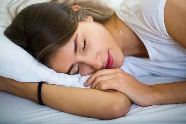 Female lying with closed eyes in bed — Stock Photo, Image