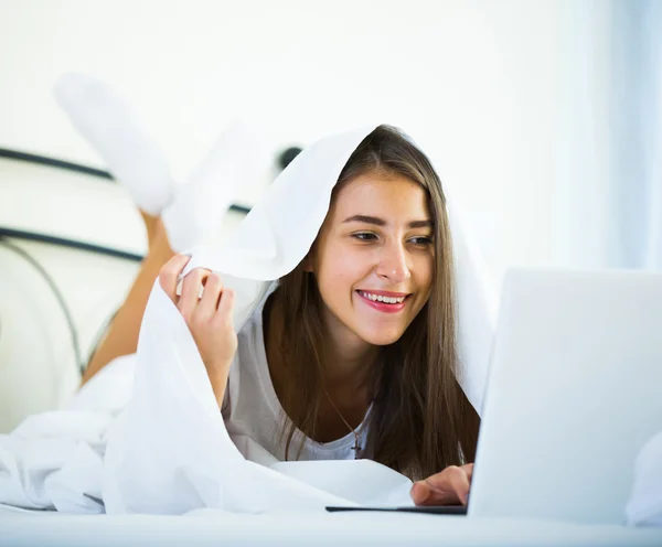 Girl chatting online covered with blanket — Stock Photo, Image