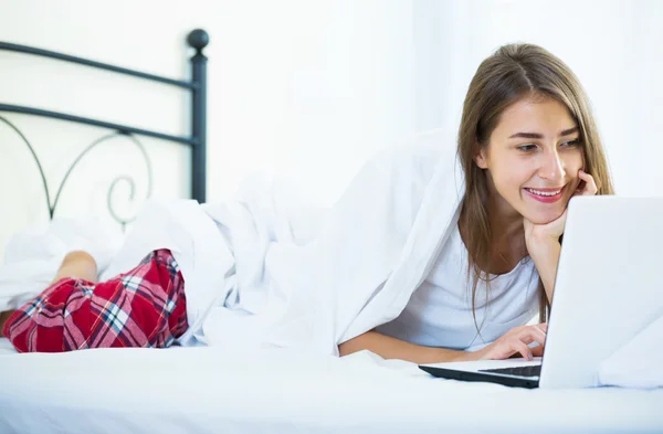 Studentin studing mit laptop im bett — Stockfoto