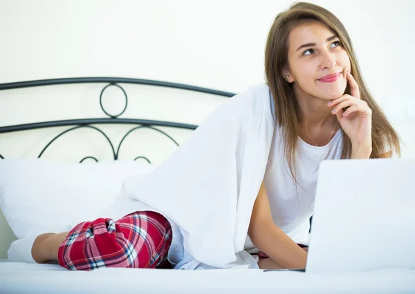 Student tjej studerar med laptop i sängen — Stockfoto