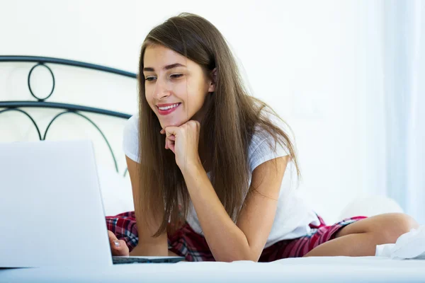 Student tjej studerar med laptop i sängen — Stockfoto