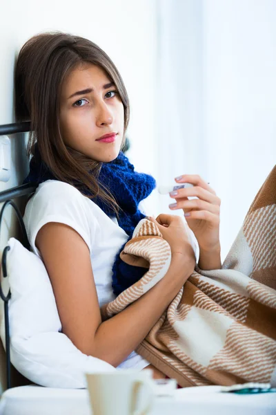 Sick teenage girl with tea and medication — Stock Photo, Image