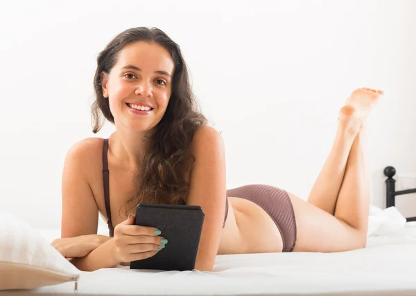 Vrouw met ereader liggend in bed — Stockfoto