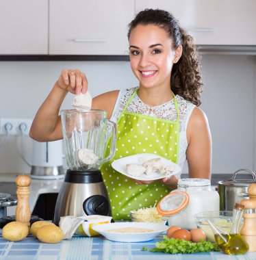 Woman with blender at kitchen clipart