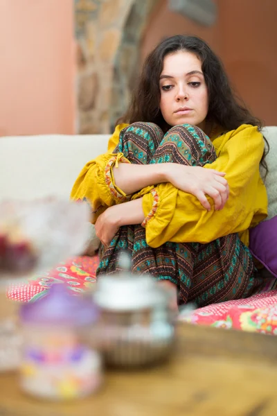 Расстроенная девушка на диване дома — стоковое фото