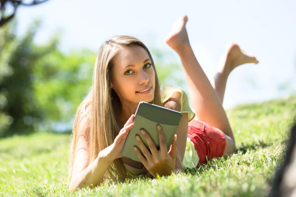 Meisje ontspannen buiten met Tablet PC — Stockfoto