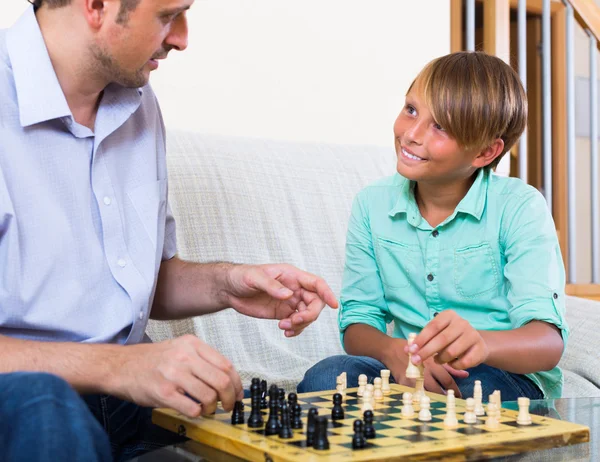 Happy parent and son playing chess — Stock Photo, Image