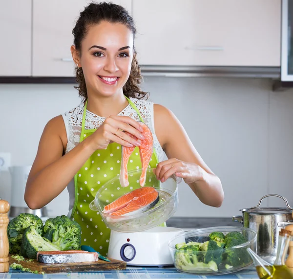 Girl preparing fish and veggies — Stock Photo, Image