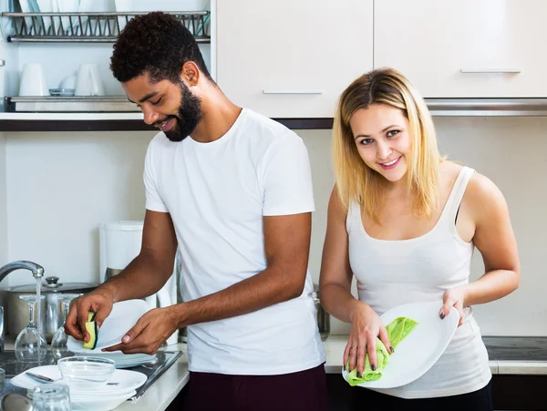 Interracial couple nettoyage dans la cuisine — Photo