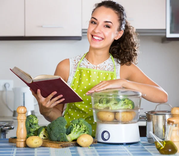 烹饪书和蒸蔬菜的女孩 — 图库照片