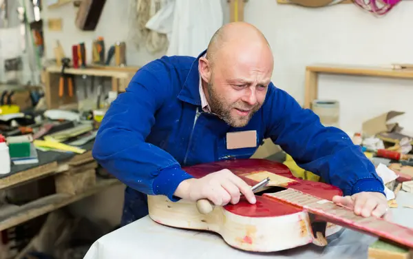 Artesão trabalhando com guitarra inacabada — Fotografia de Stock