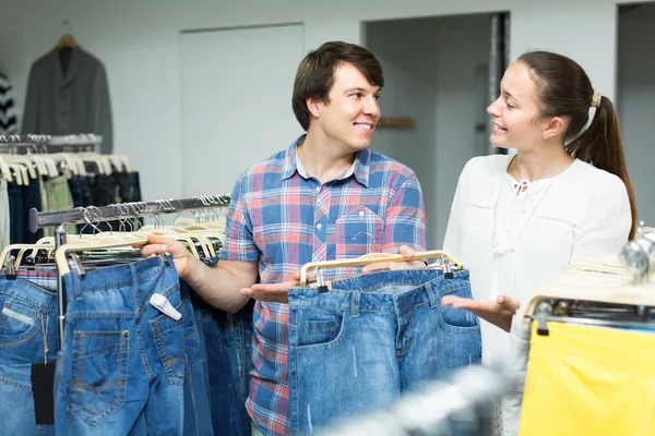 Пара выбирает джинсы в магазине — стоковое фото