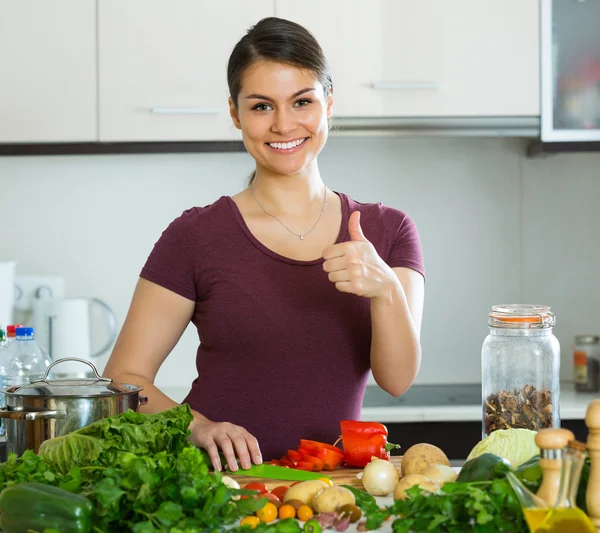 台所のテーブルで野菜を持つ女性 — ストック写真
