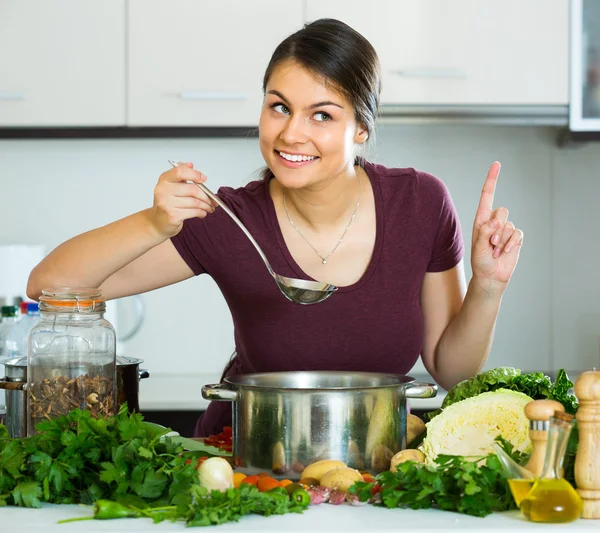 Femme aux légumes à la table de cuisine — Photo