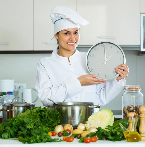 Vrouw met klok in de keuken — Stockfoto