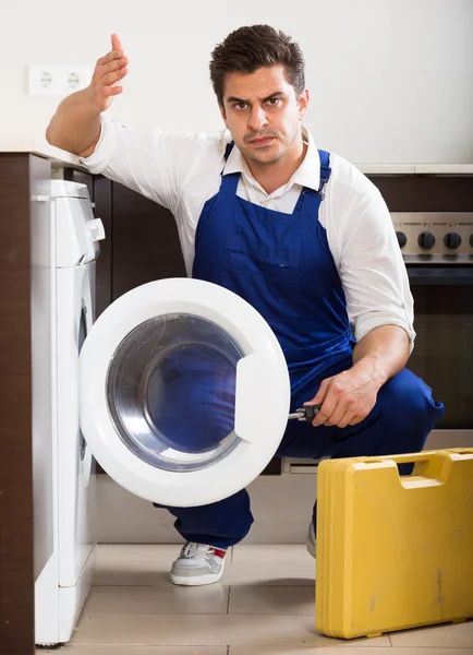 Mechanic repairing washing machine — Stock Photo, Image