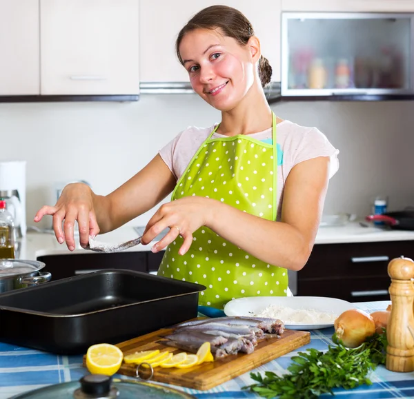 Woman putting sprats in baking — Stock Photo, Image