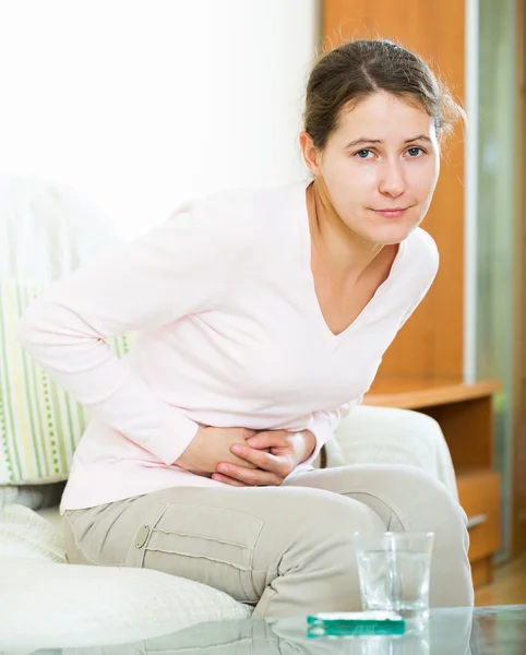 Girl folding up with belly pain — Stock Photo, Image