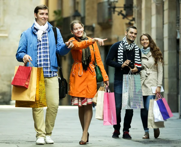 Group of young tourists with purchases — Stock Photo, Image