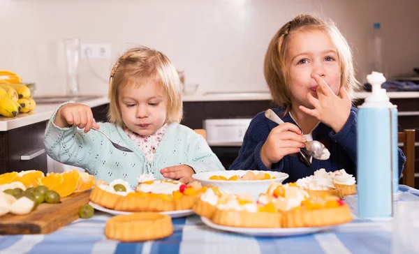 Los niños comen pasteles en la cocina —  Fotos de Stock