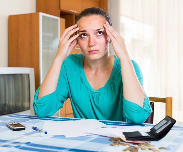 Nachdenkliches Mädchen sitzt mit ihren Rechnungen — Stockfoto