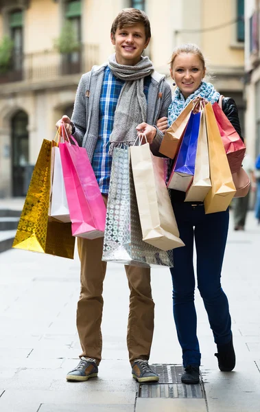 Casal de viajantes com sacos de compras — Fotografia de Stock