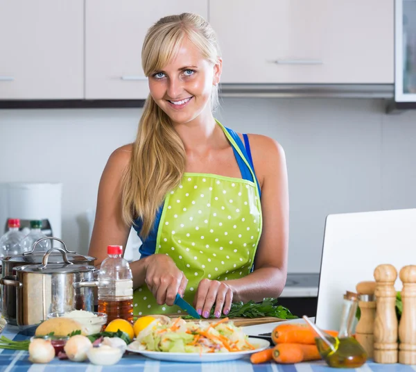 Flicka matlagning grönsaker i kök — Stockfoto