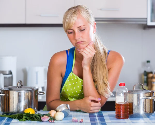 Housewife in apron standing at table — Stock Photo, Image