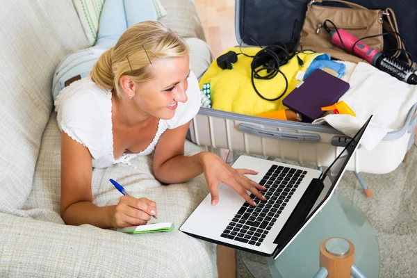 Blonde with luggage browsing web — Stock Photo, Image