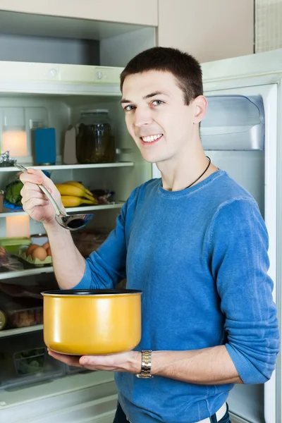 Ragazzo con casseruola vicino frigorifero — Foto Stock