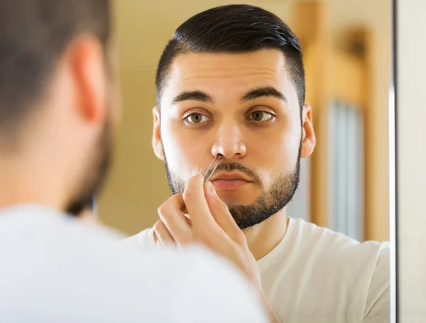 Guy removing nose hair — Stock Photo, Image