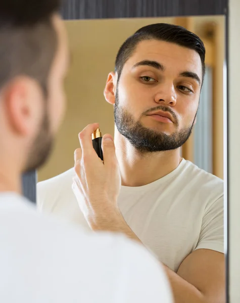 Jovem usando perfume em casa — Fotografia de Stock