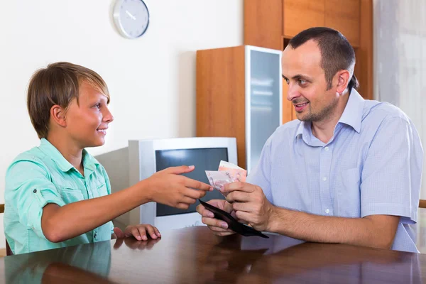 Father giving cash to teenage son — Stock Photo, Image