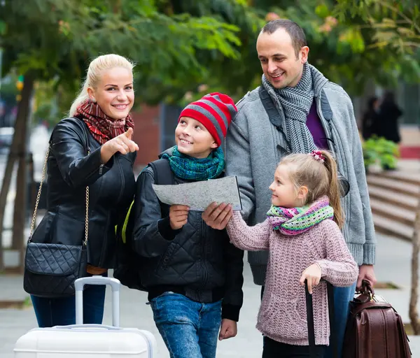 Padres con dos hijos y equipaje con mapa —  Fotos de Stock