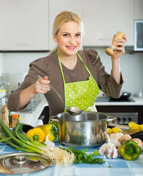 Vrouw in schort aan huis keuken — Stockfoto