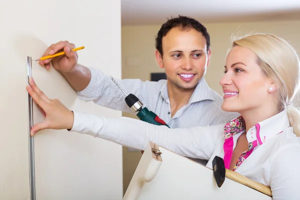 Couple choosing place for shelf — Stock Photo, Image