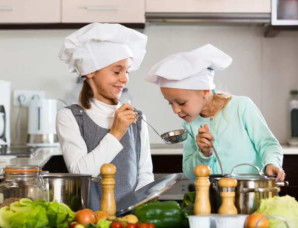 Two girls cooking vegetable soup — Stock Photo, Image