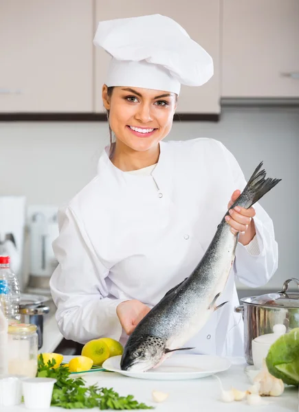 Vrouwelijke kok bereidt grote vis — Stockfoto