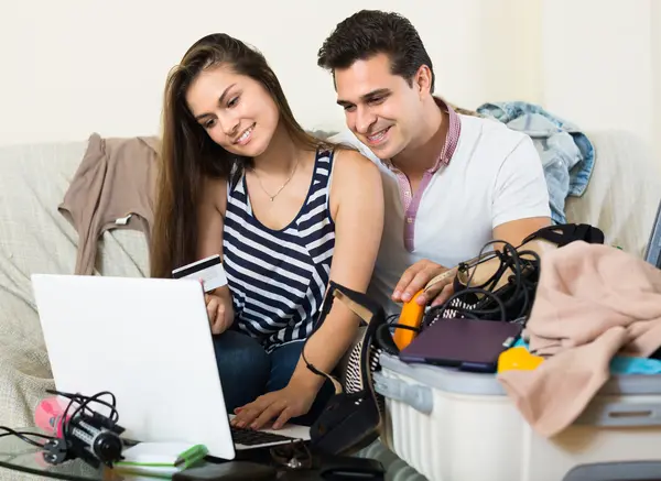 Adultos sentados cerca de laptop y equipaje — Foto de Stock