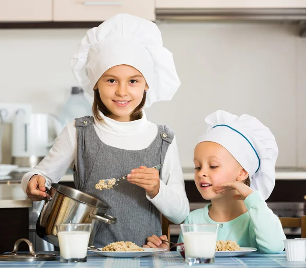 Small girls eating healthy oatmeal Royalty Free Stock Images