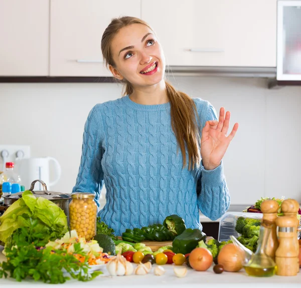 Menina jovem preparando legumes dentro de casa — Fotografia de Stock