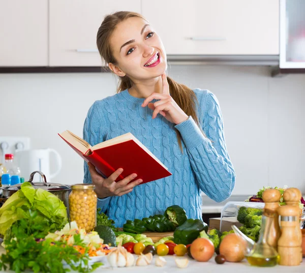 Meisje leren nieuwe recept van kookboek — Stockfoto