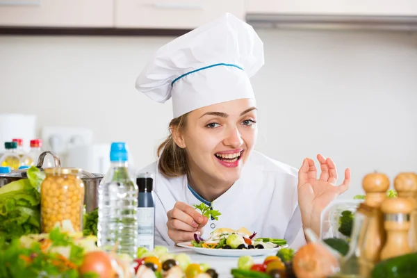 Позитивний шеф-кухар, який прикрашає салат з петрушкою — стокове фото