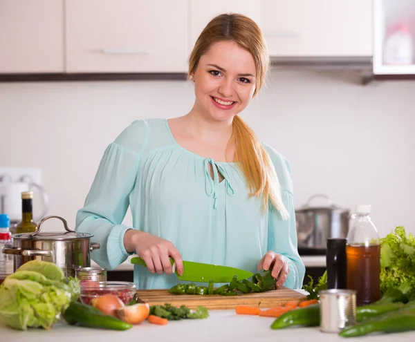 Sorridente casalinga tagliare verdure — Foto Stock