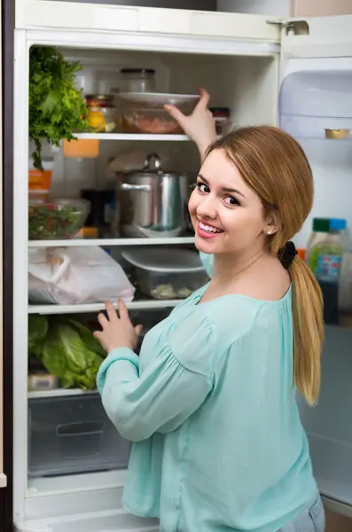 Vrouw regelen van ruimte in de koelkast — Stockfoto
